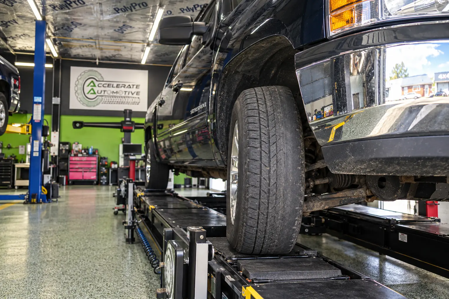 Unevenly worn front tire on an alignment rack at Accelerate Automotive in York, PA